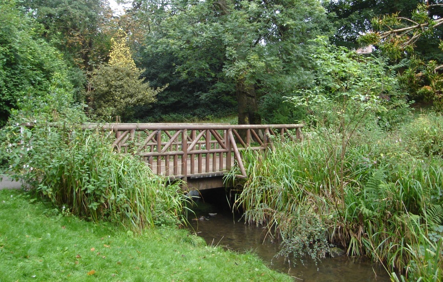 Wooden Wooden Bridge over stream in the Glen Walk in Tollcross Park